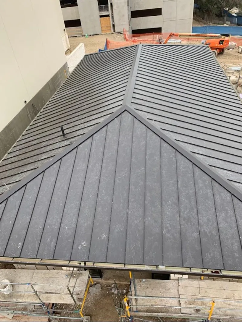 Commercial metal roof construction with crane equipment in Holly Springs